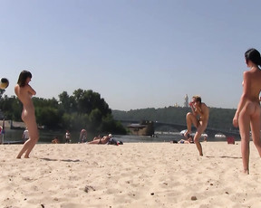 Three mesmerizing sluts sit together in water and play naked volleyball